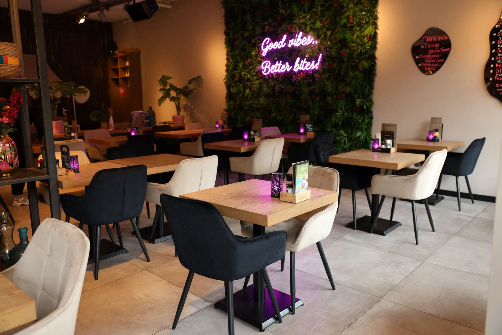 Sfeervol interieur van lunchroom Dubbel & Dwars met neon 'Good vibes, Better bites!'